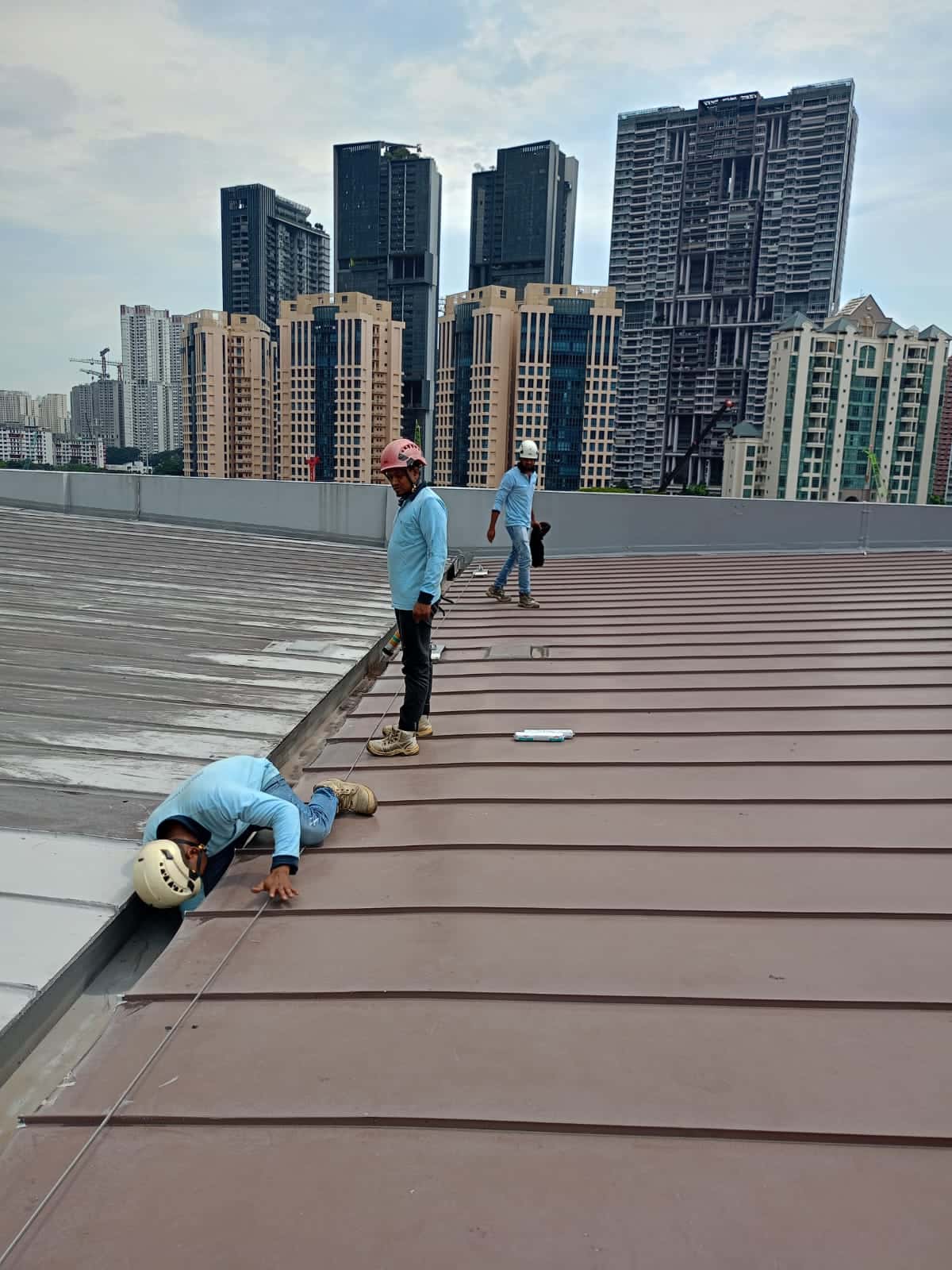 Hydroseal technicians waterproofing a metal roof in Singapore